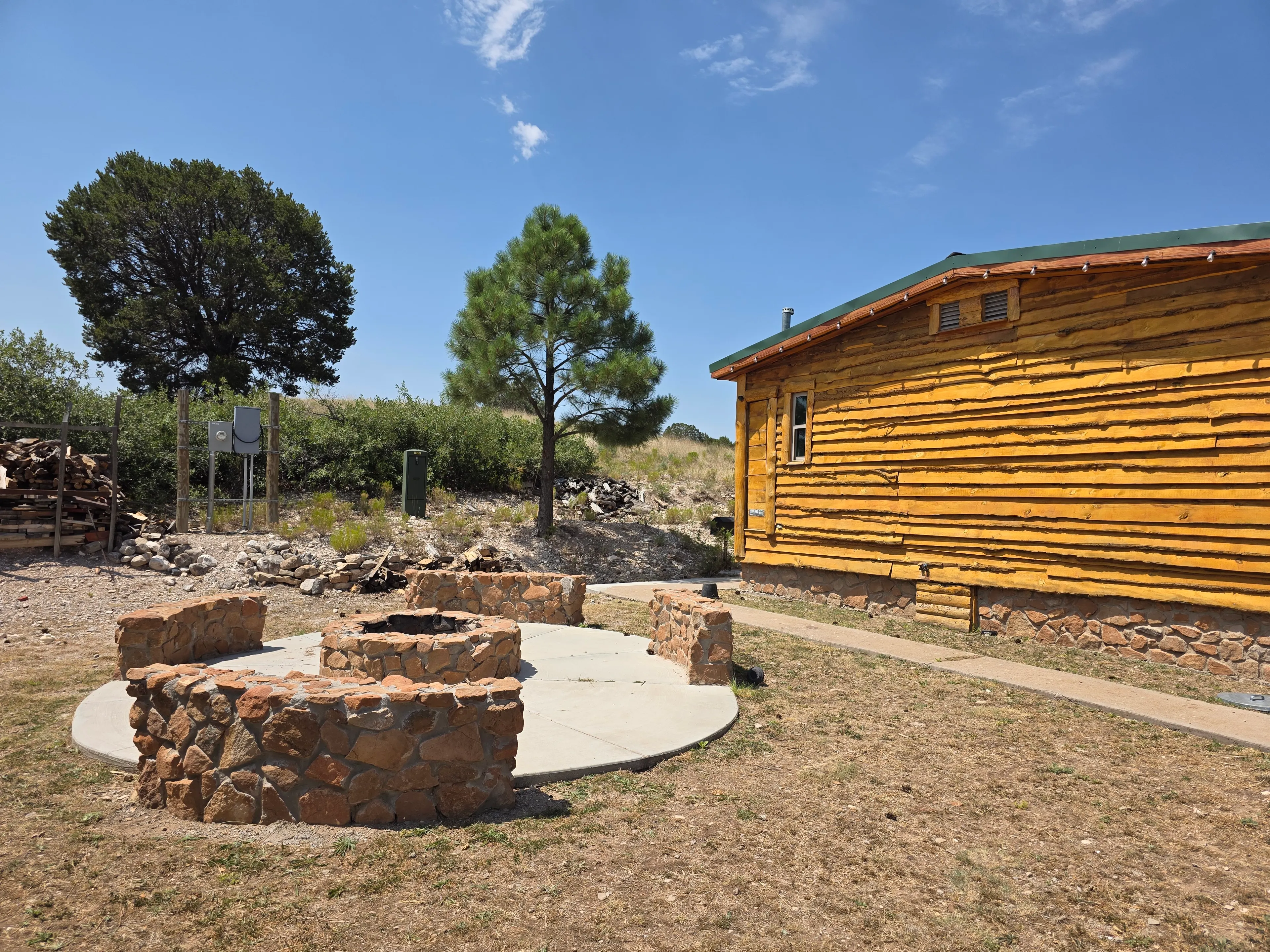 Stone fire pit beside cabin