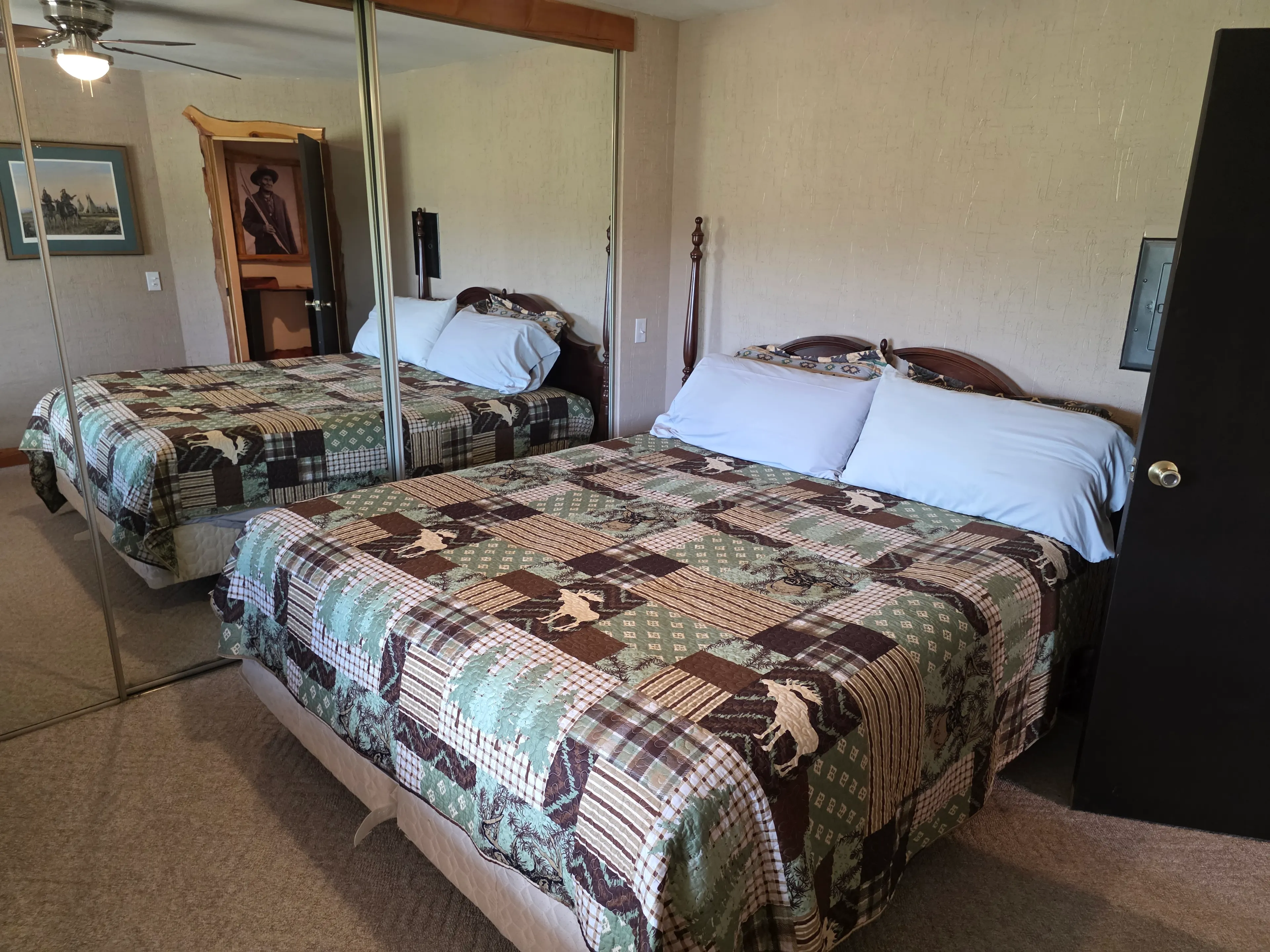 bed with lodge quilt, mirrored closet