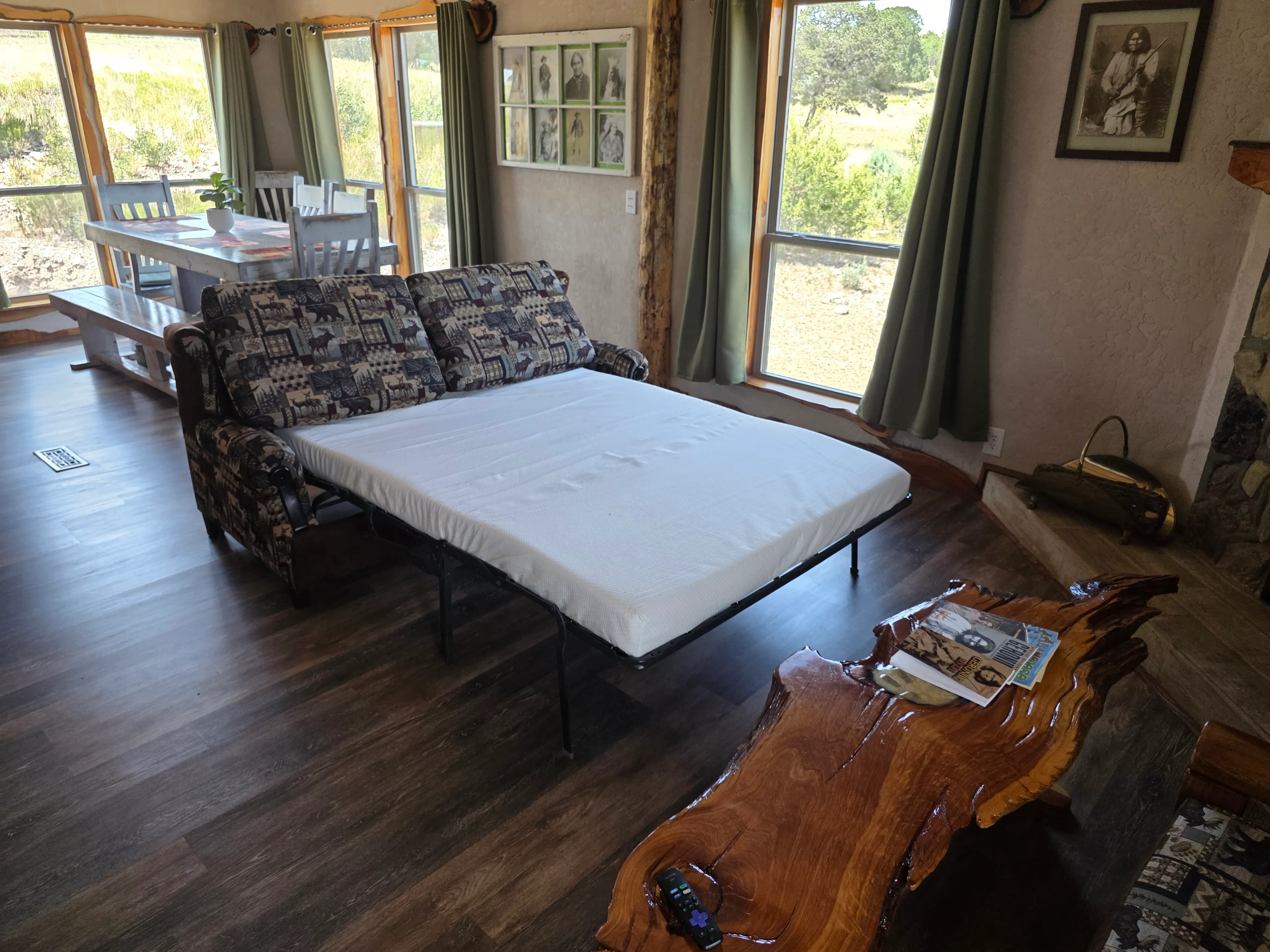 Sleeper sofa pulled out, dining behind