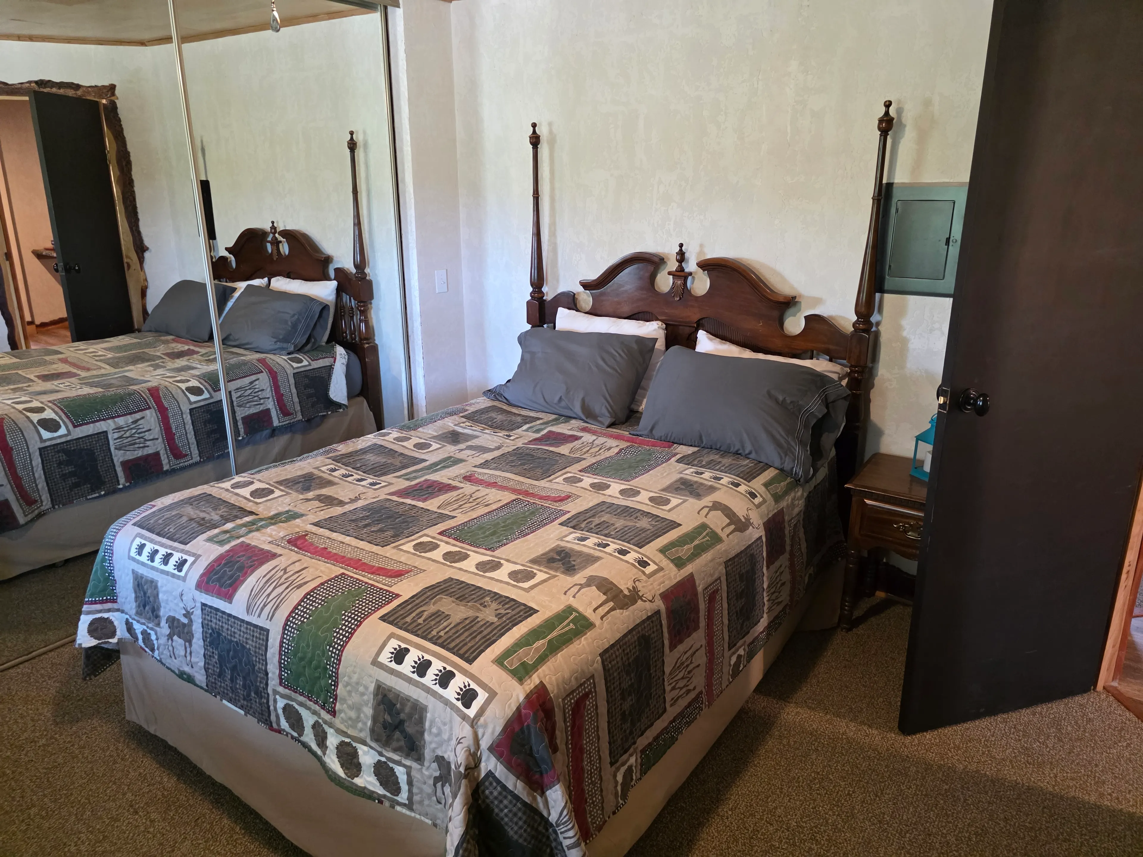 Queen bed beside mirrored closet
