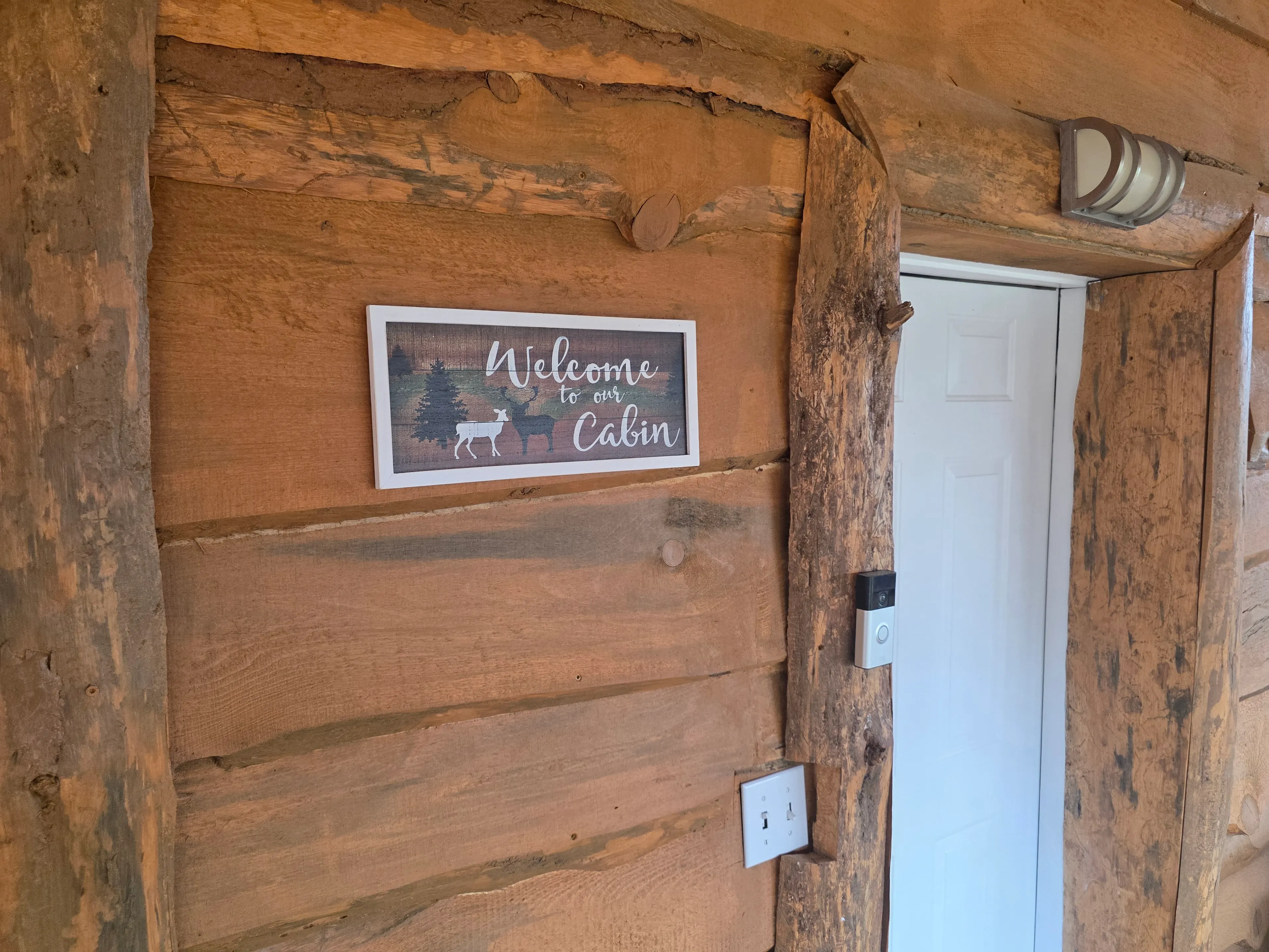 welcome sign at log cabin entry