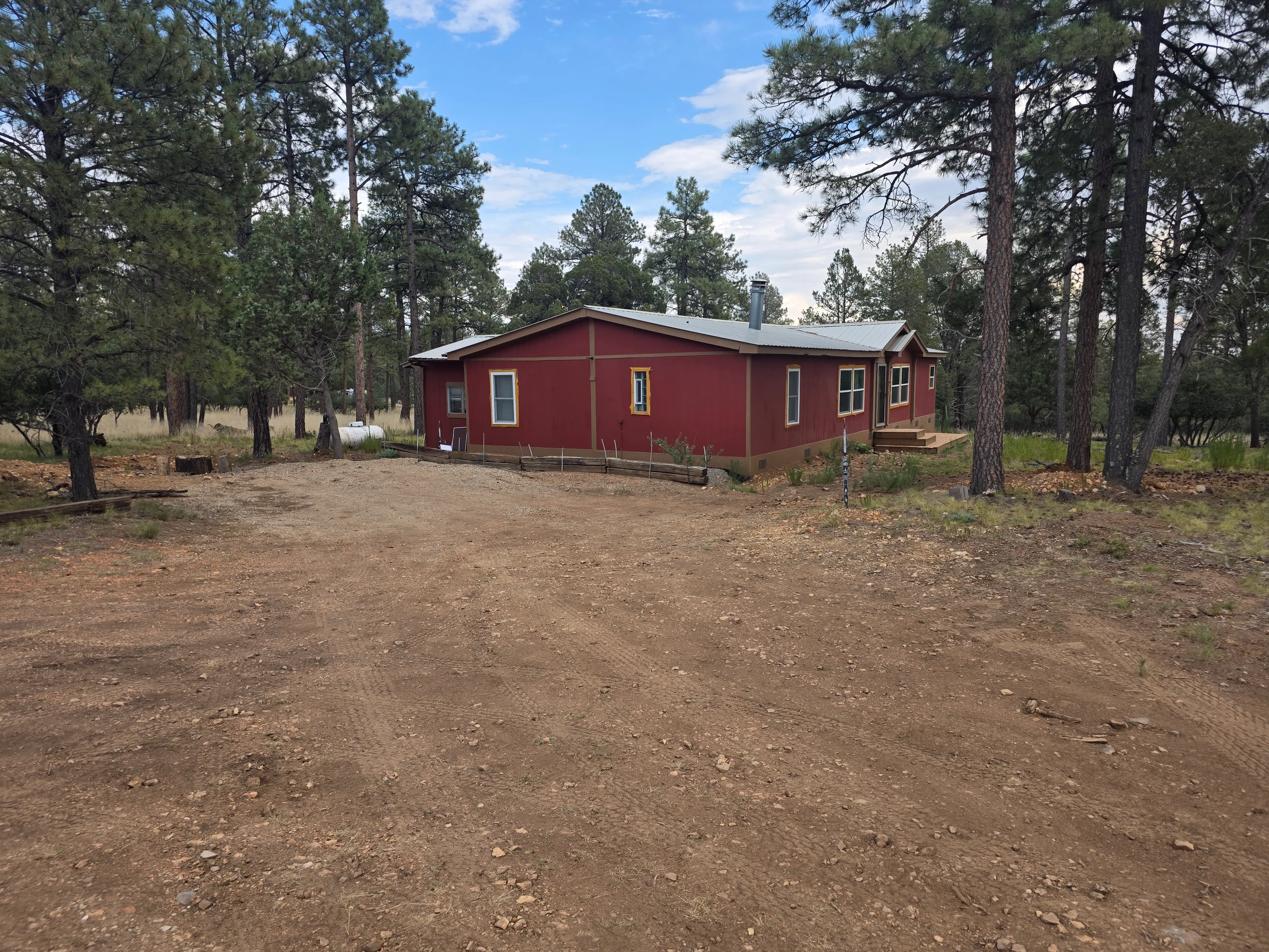 red cabin exterior with gravel drive