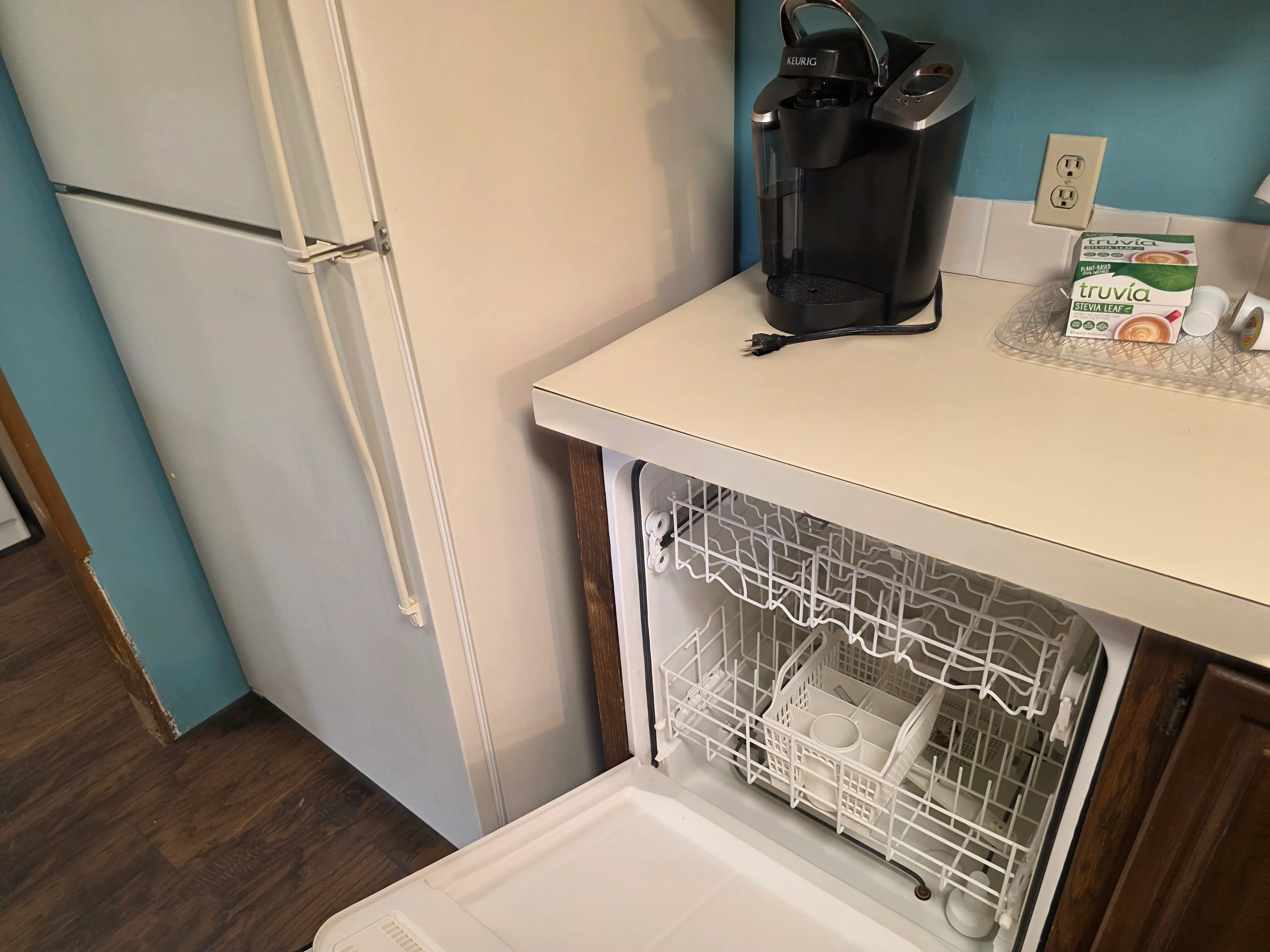 open dishwasher beside refrigerator